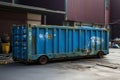 A substantial iron container, the blue dumpster designed for municipal solid waste