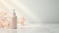 A subtle, elegant display features a bottle of lotion beside delicate pink flowers on a marble surface, illuminated by Royalty Free Stock Photo