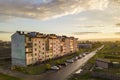 Suburb landscape, apartment building. Parked cars along bad road on spring day on blue sky copy space background Royalty Free Stock Photo