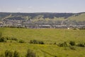 Suburb and villages. Big mountains and dark green forests far away. Trees and their shadows on the grass. Summer day with bright b Royalty Free Stock Photo