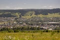 Suburb and villages. Big mountains and dark green forests far away. Trees and their shadows on the grass. Summer day with bright b Royalty Free Stock Photo