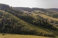 Suburb and villages. Big mountains and green forests. Trees and their shadows on the grass. Summer day with calm deep blue sky and Royalty Free Stock Photo