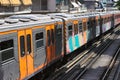 Suburban commuter passenger train entering station in sunny day.