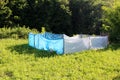 Suburban family house small urban home garden protected with makeshift improvised blue and white nylon fence Royalty Free Stock Photo