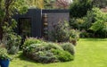 Suburban garden in London UK, with sustainable eco friendly garden studio room with green living sedum  roof. Royalty Free Stock Photo