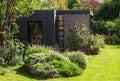 Suburban garden in London UK, with sustainable eco friendly garden studio room with green living sedum  roof. Royalty Free Stock Photo