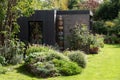 Suburban garden in London UK, with sustainable eco friendly garden studio room with green living sedum  roof. Royalty Free Stock Photo