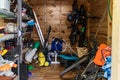 Suburban home wooden storage utility unit shed with miscellaneous stuff on shelves, bikes, exercise machine, ladder