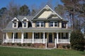 Suburban home with a yellow exterior and a large porch