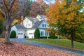 Suburban House among autumn trees. Large manicured lawn and landscaping