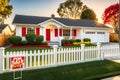 Suburban House Bathed in Golden Hour Light - Front Lawn Freshly Mowed, White Picket Fence, For Sale Royalty Free Stock Photo