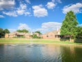 Suburban lakefront houses with water fountain and green grass lawn near Dallas Royalty Free Stock Photo