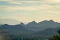 Suburban neighborhoods in the distance in Tuscon Arizona with jaged and pointy sillouhette moutains in the distance