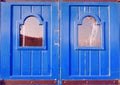 Suburban old fashioned double door of vibrant blue colour with broken window in Marsaskala, Malta Royalty Free Stock Photo