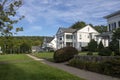 suburban homes houses on a walkway street with grass, trees on a blue sky day Royalty Free Stock Photo