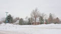 Suburban street with typical canadian houses, bare tree and steet lantern in the snow