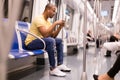 Subway passenger male sitting in car seat and using phone
