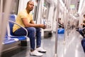 Subway passenger male sitting in car seat and using phone