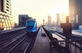 Subway train at sunset in modern city. Dubai metro. Downtown skyline with sundown. Skyscraper buildings and car traffic. Royalty Free Stock Photo