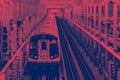 Subway train traveling on tracks across the Williamsburg Bridge from Brooklyn to Manhattan in New York City with red blue colors Royalty Free Stock Photo