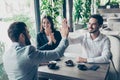 Success and agreement between three business partners, they celebrate sitting in cafe, wearing suits, smiling. Terrace is Royalty Free Stock Photo