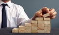 Success in business and career. Man rises figurine on a ladder from wooden blocks.