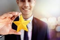 Success in Business or Personal Talent Concept. Happy Businessman in black suit Smiling and Showing a Golden Star in Hand