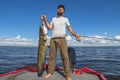 Success catfish fishing. Happy fisherman with big sheatfish trophy at boat Royalty Free Stock Photo