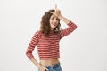 Success comes to determined people. Indoor shot of emotive attractive young woman in red striped cropped top holding