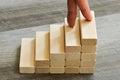 Success Concept - Fingers Climbing Up To Top Of Stairway Over Dark Wooden Background