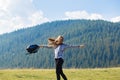 Hiker woman cheering elated and blissful with arms raised in sky after hiking to mountain top Royalty Free Stock Photo