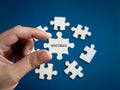 Success concept. Word SUCCESS showing on puzzle jigsaw piece holding by business person's hand.