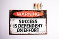 Success is Dependent on Effort. Warning sign with text on a white background