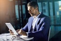 Success doesnt only happen between 9-5. a businessman using a digital tablet while woking late at the office. Royalty Free Stock Photo