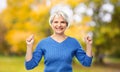 Happy old woman celebrating success in autumn park Royalty Free Stock Photo