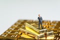 Success finance investment wealth concept, miniature figure businessman standing on stack of shiny gold bar bullions ingot Royalty Free Stock Photo
