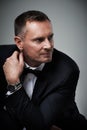 Success, handsome and mature man in tuxedo and serious and isolated on grey background in studio. Luxury, glamour and