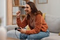 Success, happy and a woman gaming on the sofa with a win, celebration and excited about competition. Smile, house and a Royalty Free Stock Photo