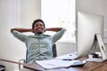 Success has got him smiling. Portrait of a young designer taking a break at his office desk. Royalty Free Stock Photo