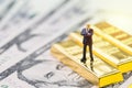 Success in investment, wealth management or financial crisis safe haven concept, miniature people businessman standing on gold ba Royalty Free Stock Photo