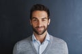 Success makes me smile. Portrait of a handsome young businessman posing against a dark background. Royalty Free Stock Photo