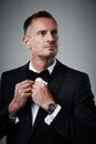 Success, mature man in tuxedo with bow tie, handsome online dating profile picture isolated on grey background in studio
