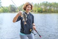 Success perch fishing. Lady fisherwoman with fish at lake