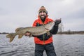 Success pike fishing. Happy fisherman with big fish trophy at boat Royalty Free Stock Photo