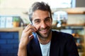 Success and smiles all around. Portrait of a handsome young man talking on a phone in a cafe. Royalty Free Stock Photo