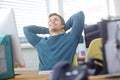 Success is something to be proud of. a content young office worker leaning back in his chair with his hands behind his