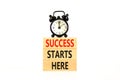 Success starts here symbol. Concept word Success starts here on beautiful wooden block. Black alarm clock. Beautiful white Royalty Free Stock Photo