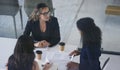 Success stems from communication. High angle shot of three young businesswoman sitting in the boardroom during a