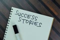 Success Stories write on a book isolated on Wooden Table