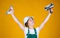 success. teen girl use putty knife. builder in coveralls and helmet with spatula. kid repair wall with spackling paste Royalty Free Stock Photo